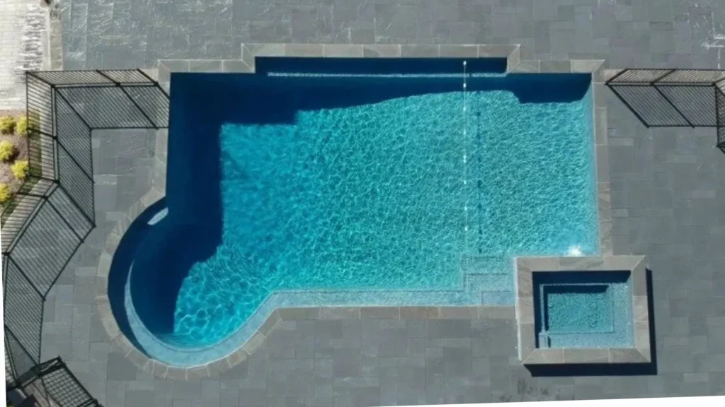 Aerial view of a geometric in-ground pool with attached square spa and large bluestone patio surround in New Jersey by Gorlin Pools